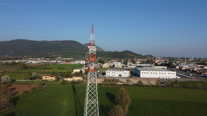 Obraz premium High-voltage electricity pylon in a rural landscape with industrial area