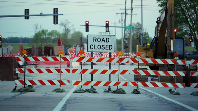 Blocked roadway with barricades and warning sign ROAD CLOSED showing restricted access and construction area.
