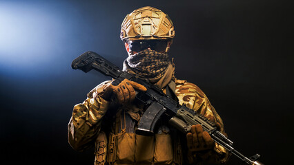 Naklejka premium Tactical soldier with rifle on black smoky background. Concept military duty and strength. 