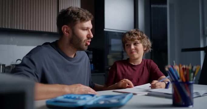 Parent Helps Child With Studies. Dad Provides Patient Guidance To His Son During Homework Time