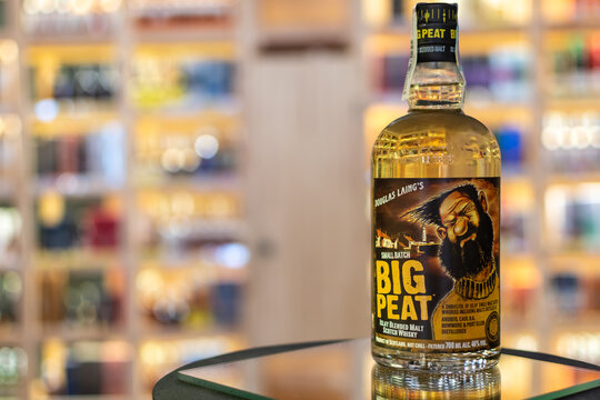Bottle of Big Peat Islay Blended Malt Scotch Whisky by Douglas Laing on a mirror surface in a liquor store with warm blurred shelves in background. Ukraine, Zhytomyr, April 29, 2026