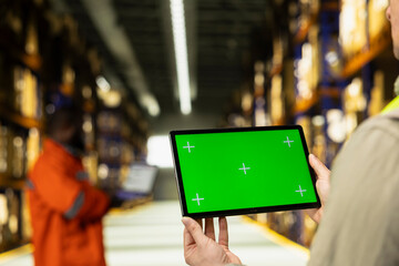 Obraz premium Chroma key screen with employee working on shipping operations in large business depot facility. Manual labor workforce manages cargo packages and enables e-commerce order fulfillment.