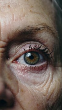 Mature woman green iris eye extreme close up showing detailed skin texture and eyelashes