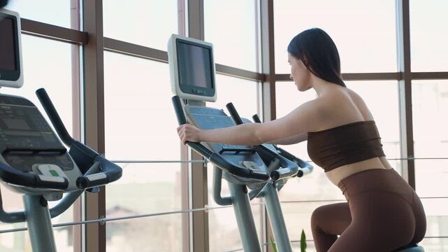 Fit woman pedaling on stationary bike during cardio workout