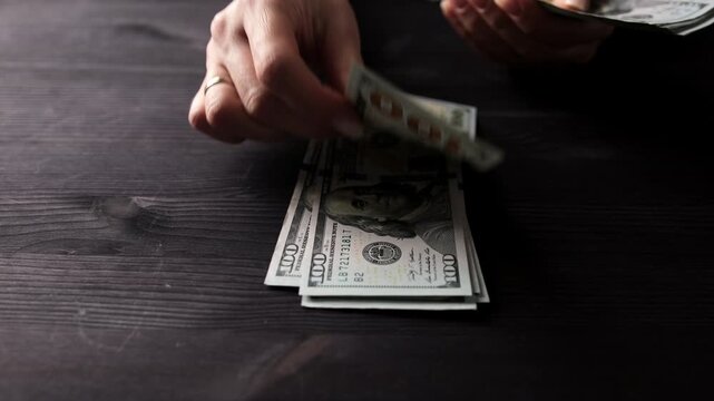 Woman's Hands Counting Stack Of Us Dollar Bills