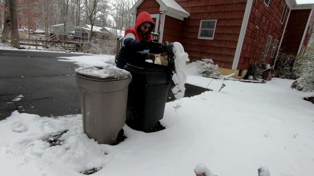 woman emptying the recycling trash in the backyard after the snow storm in February