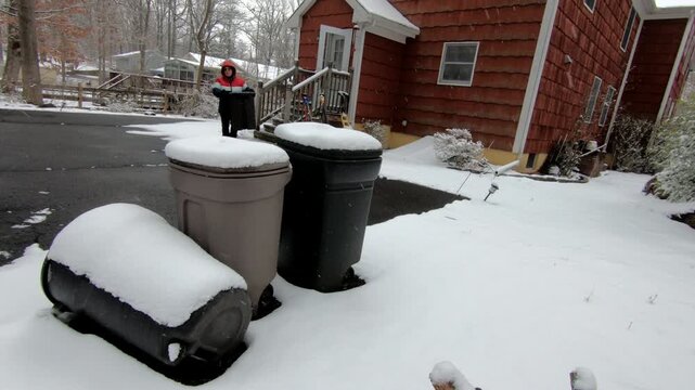 woman emptying the trash in the backyard after the snow storm in February