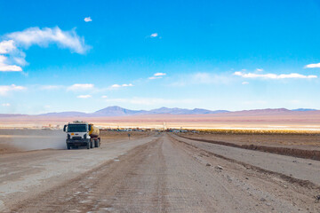 Heavy industrial truck driving on a dusty gravel road in the Puna de Atacama desert near Tolar Grande, Salta, Argentina. Logistic transportation © Valentin