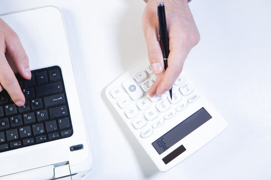 female hands holding laptop and calculator