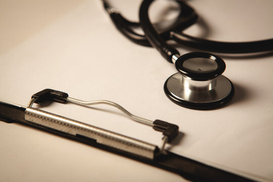 stethoscope and notebook on the white table.
