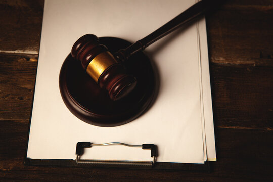 Wooden judge gavel and law book on wooden table background.