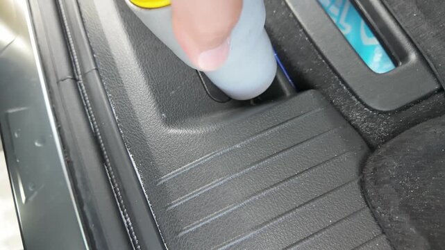 vacuuming crumbs and dust from car trunk threshold