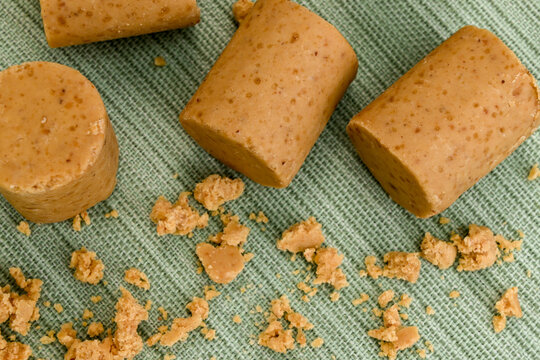 Traditional Brazilian Peanut Candy Known as Pacoca De Amendoim Arranged on a Green Textured Fabric with Crumbled Pieces, a Popular Sweet Treat Often Served During Festa Junina Celebrations