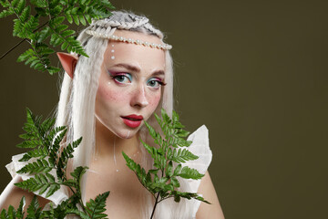 Naklejka premium Beautiful elf girl with floral decor on dark olive background, space for text