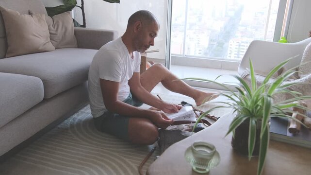 Man sitting on the living room floor building a bouncer for his newborn child