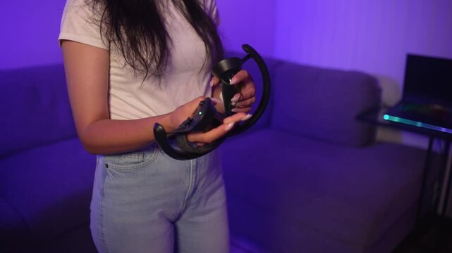 Young woman holding VR controllers preparing for virtual reality gaming at home setting up equipment and entering modern digital gaming experience with virtual reality technology