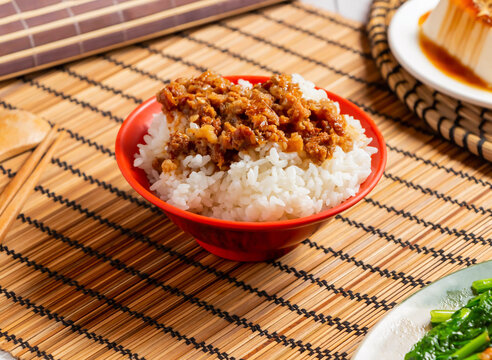 Traditional taiwanese braised pork rice lu rou fan in a red bowl on a bamboo mat