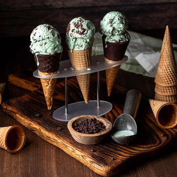 Mint chocolate chip ice cream cones in a dark setting.
