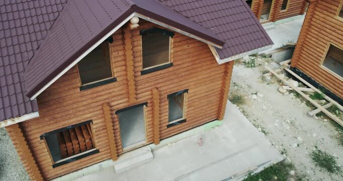 Construction site of round wooden log house village, aerial drone view