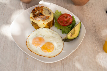 Traditional Latin breakfast featuring rice plantain fried eggs avocado and fresh vegetable salad. © Alejandro
