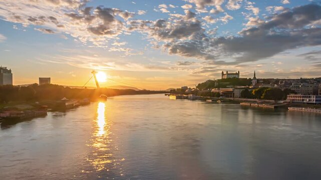 Bratislava old town and SNP bridge at sunset over of calm Danube river hyper lapse. Slovakia.