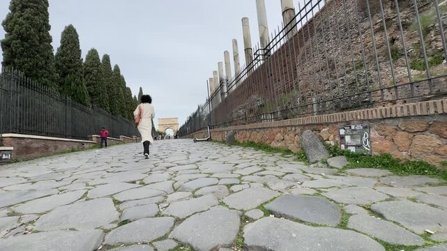 Young attractive female tourist exploring Rome city at spring looking at panoramic view off Roman Forum