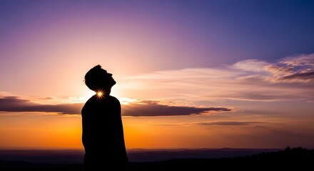Fototapeta premium Silhouette of a person admiring a beautiful sunset, capturing a moment of serenity. The person stands against the backdrop of a vibrant sky, their silhouette a symbol of contemplation