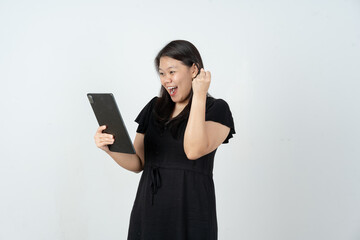 Naklejka premium Cheerful Asian woman celebrating success while looking at tablet screen