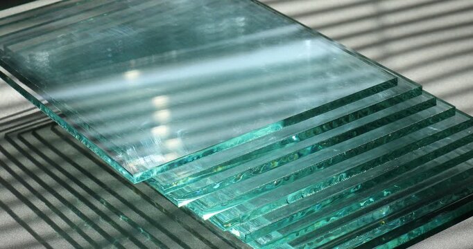 Stack of glass sheets on grey table, closeup