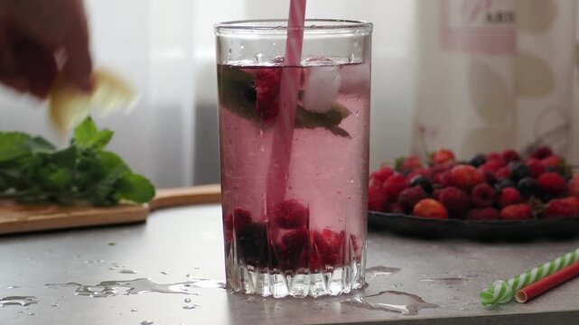 Summer drinks, colored cocktails on table. Lemonade, mojito, strawberry lemonade, tonic water. A refreshing summer drink with raspberries and blueberries, a detox drink for weight loss and keeping fit