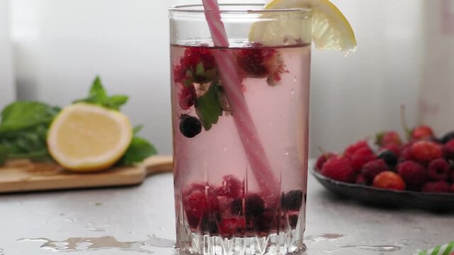 Summer drinks, colored cocktails on table. Lemonade, mojito, strawberry lemonade, tonic water. A refreshing summer drink with raspberries and blueberries, a detox drink for weight loss and keeping fit