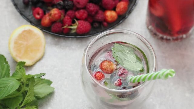 Summer drinks, colored cocktails on table. Lemonade, mojito, strawberry lemonade, tonic water. A refreshing summer drink with raspberries and blueberries, a detox drink for weight loss and keeping fit