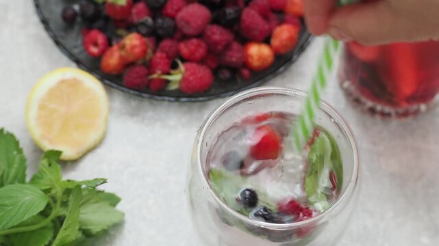 Summer drinks, colored cocktails on table. Lemonade, mojito, strawberry lemonade, tonic water. A refreshing summer drink with raspberries and blueberries, a detox drink for weight loss and keeping fit