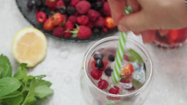 Summer drinks, colored cocktails on table. Lemonade, mojito, strawberry lemonade, tonic water. A refreshing summer drink with raspberries and blueberries, a detox drink for weight loss and keeping fit