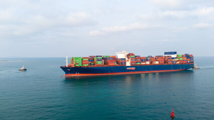 Fototapeta premium large container ship fully loaded with colorful cargo containers sailing in the deep blue sea. Global maritime logistics, international trade, and shipping industry concept.
