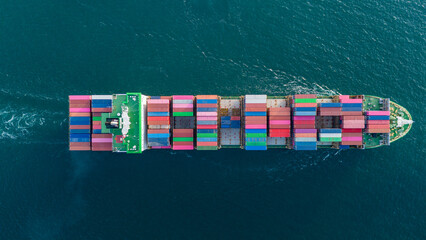 large cargo container ship fully loaded with colorful containers sailing through the deep blue ocean. Global maritime trade, freight transport and logistics business. © Yellow Boat