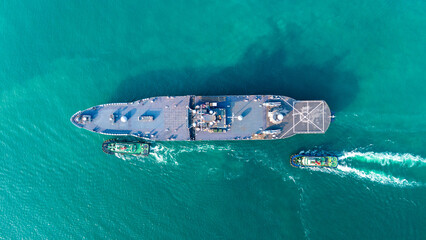 large naval amphibious assault ship being assisted by tugboats in the strategic Strait of Hormuz....