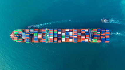 Fototapeta premium container ship fully loaded with colorful cargo containers being assisted by tugboats in the open sea. Concept of global maritime logistics, international trade, and heavy shipping operations.
