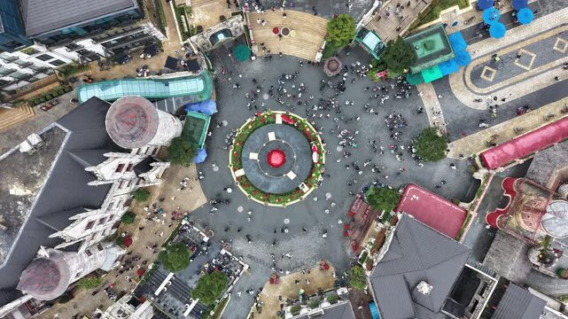 Vietnam, Da Nang, Ba Na Hills Aerial View Central Plaza Asian Tourists Castle Spires Circular Fountain Paved Pathways Vendor Stalls Families Tour Guides Street Performers Overcast Light