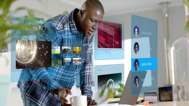 Man typing and tapping laptop causing tech UI updating contacts cycling media reaching mug for work