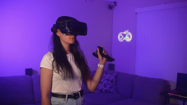 Young woman wearing VR headset waving hand controlling virtual environment interacting with digital space and entering modern interactive gameplay experience