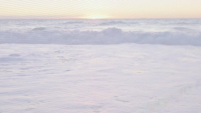 Incoming swell pushing ocean waves, cresting and breaking into foamy surf, driven by shore