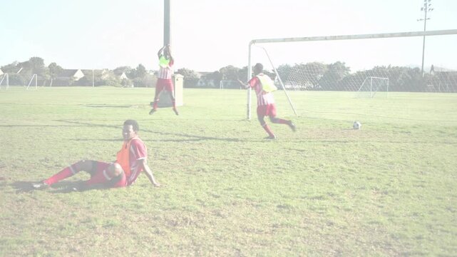 Four players controlling ball in soccer, attacking, sliding tackle sending ball to right goal line