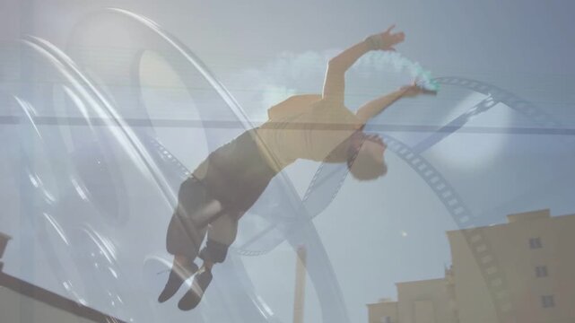 Parkour trainee pausing on roof, launching backflip, trailing teal smoke, landing on mat, film arcs