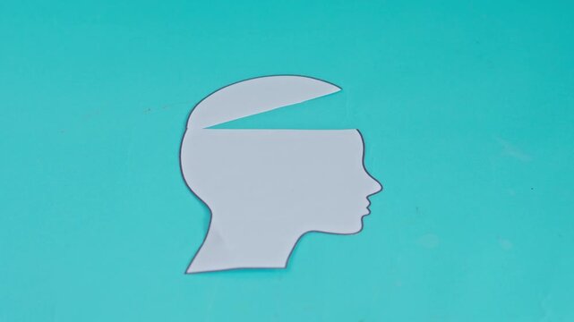 Stop-motion animation of paper head silhouette opening up to reveal tangled white string