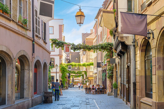 A picturesque street of sidewalk cafes and boutiques in the Quartier des Tonneliers district, a vibrant, historic pedestrian area in central Strasbourg France City-Centre - Petite France district.