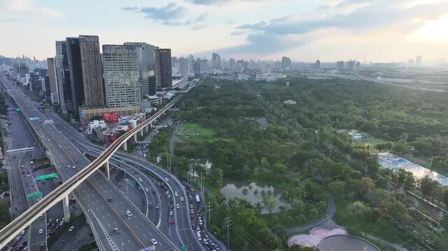 BTS skytrain rail line running above roads between buildings and city blocks. Elevated track connects urban areas with transportation system.