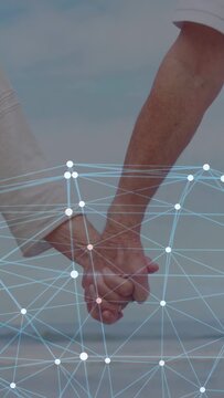 Vertical video: Seniors walking shore holding hands causing network brightening showing health data