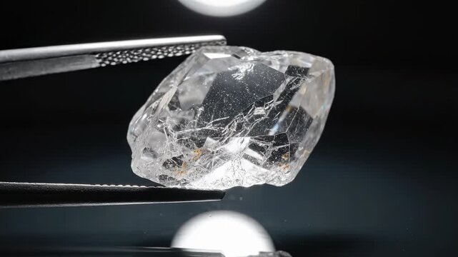 Raw diamond held by tweezers