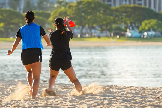 Two women opponents playing friendly game of frisbee